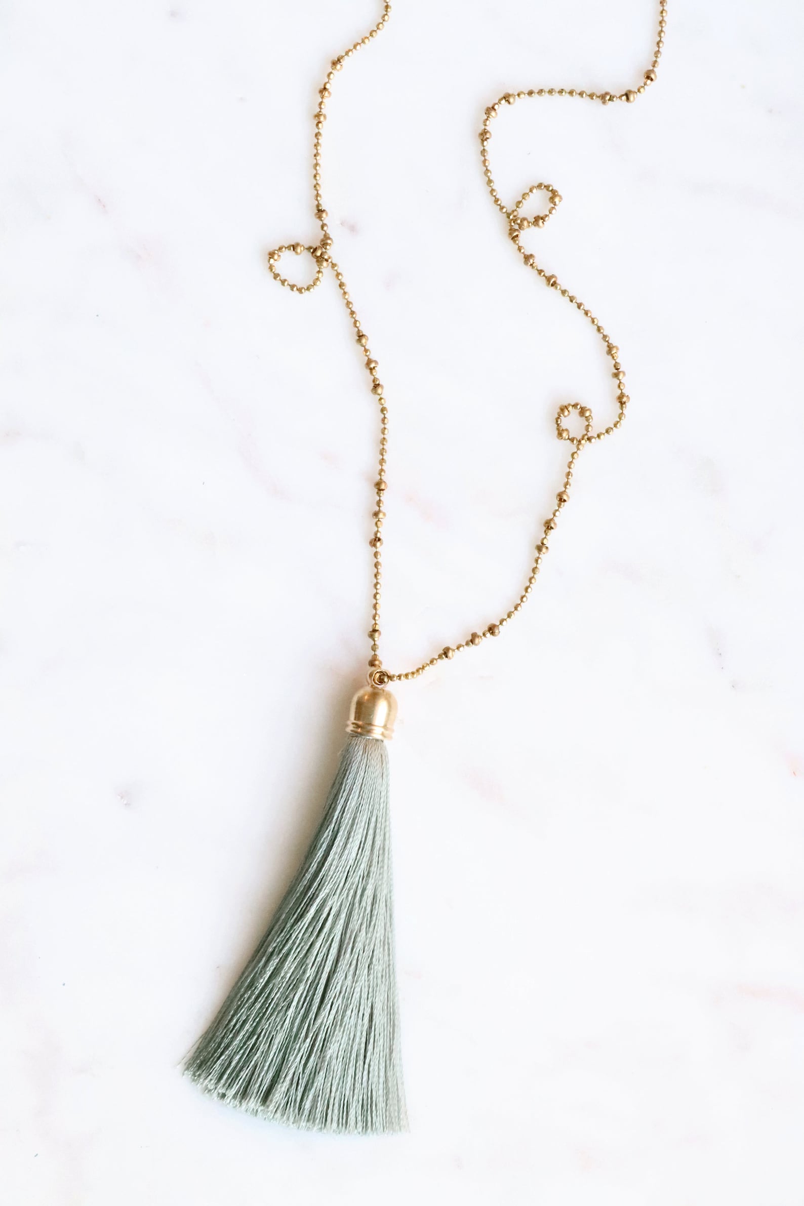 Lovely golden tassel necklace! Pair it with a top in ivory to make a chic look.